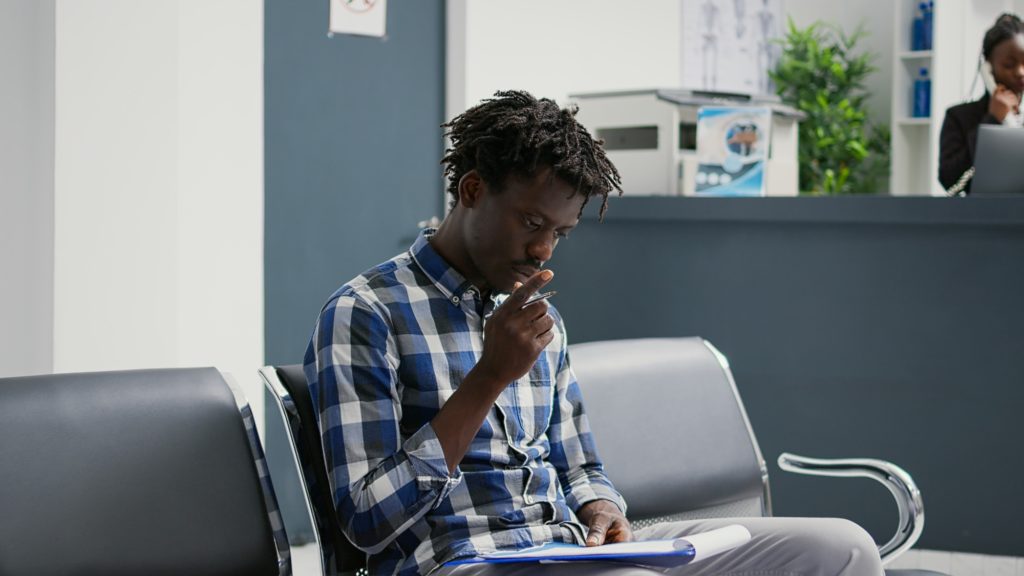 African american patient filling in checkup report papers